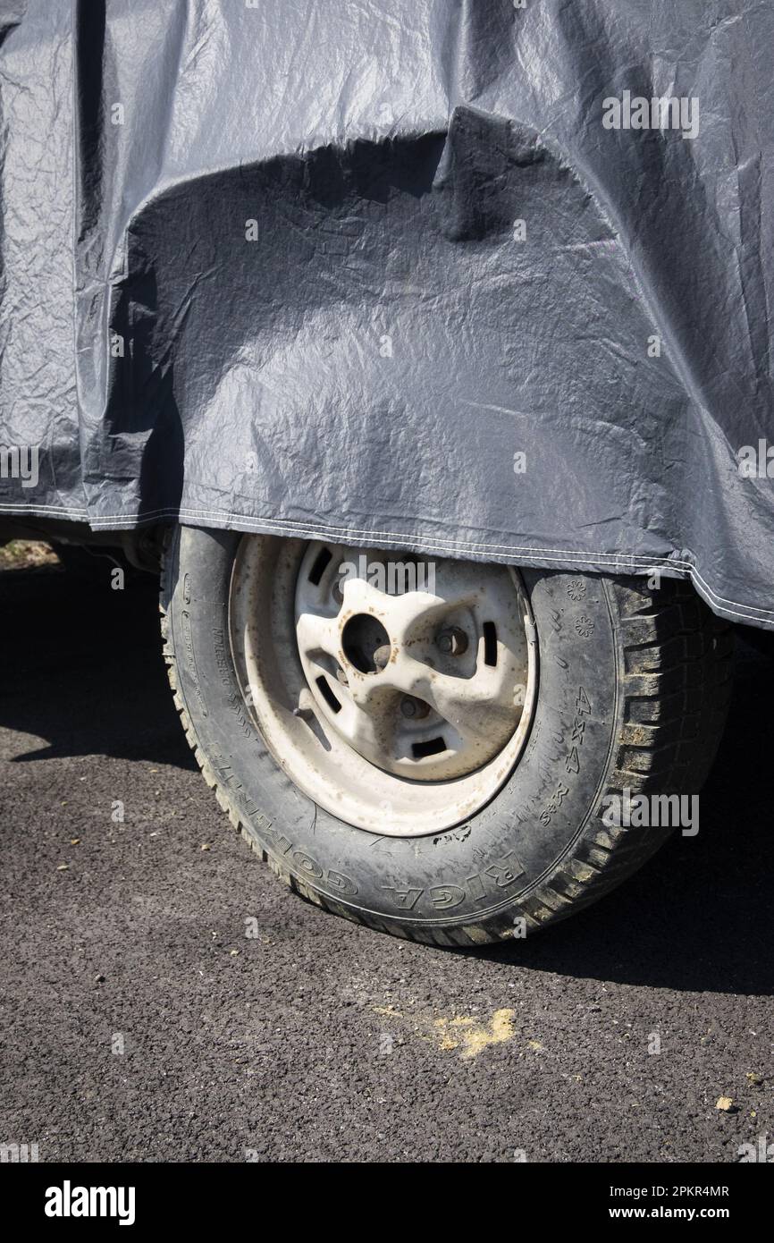Roue de disque de voiture garée partiellement couverte Banque D'Images