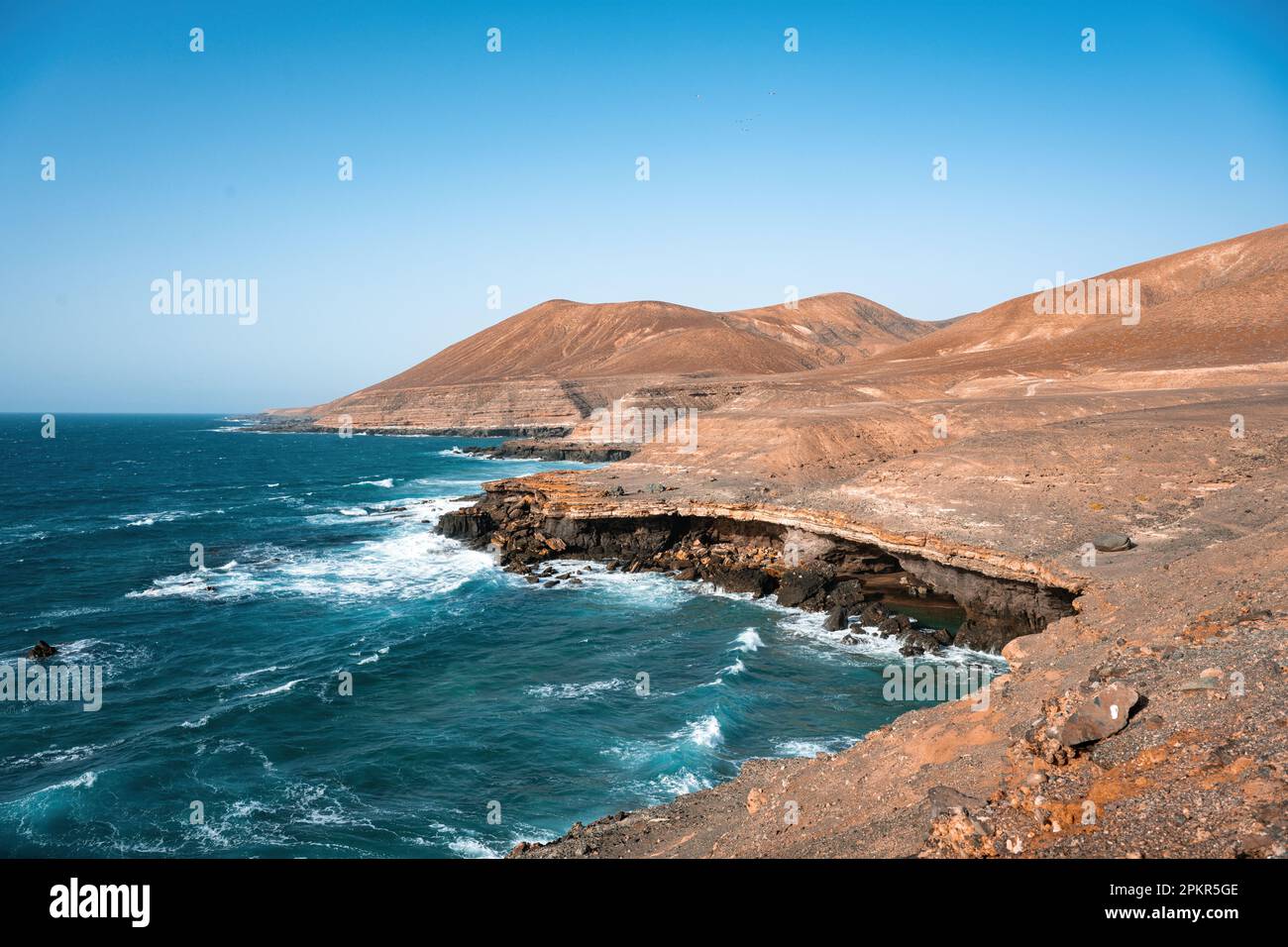 Vue imprenable sur une côte rocheuse baignée par un magnifique océan bleu. Playa del Aguila (Plage des Eagles) Fuerteventura, Îles Canaries, Espagne. Banque D'Images