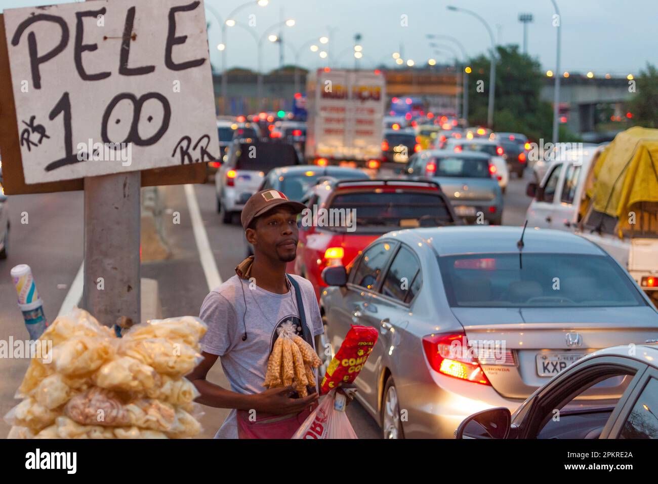 Les habitants de Complexo da Mare, un réseau massif de favelas qui se trouve le long de la Linha Vermelha (ligne rouge), l'autoroute principale de l'aéroport international de Rio de Janeiro au centre-ville, travaillent comme vendeurs de rue pendant les heures de pointe à l'expreessway. Banque D'Images