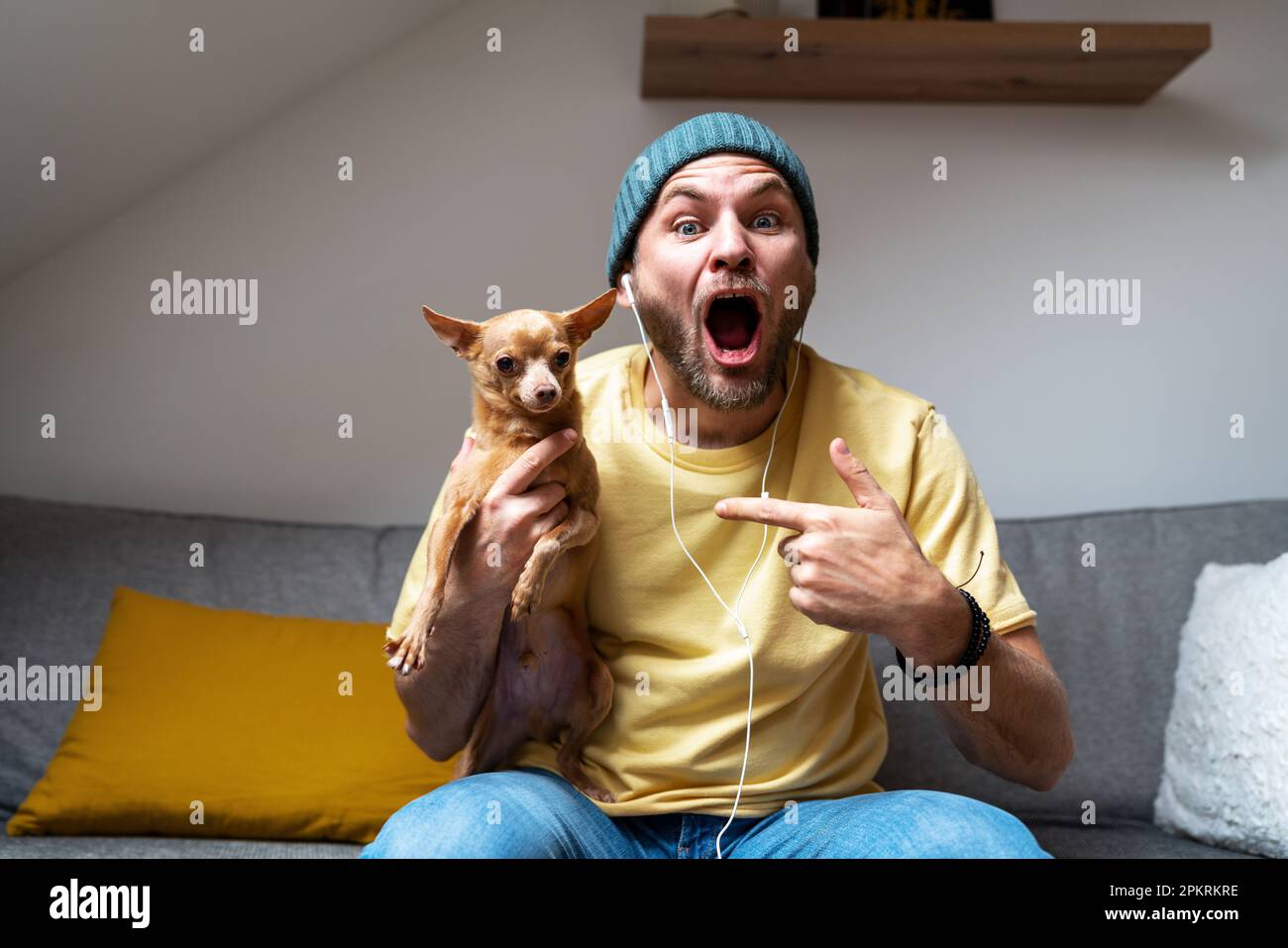 Homme surpris et petit chien de tour. Banque D'Images