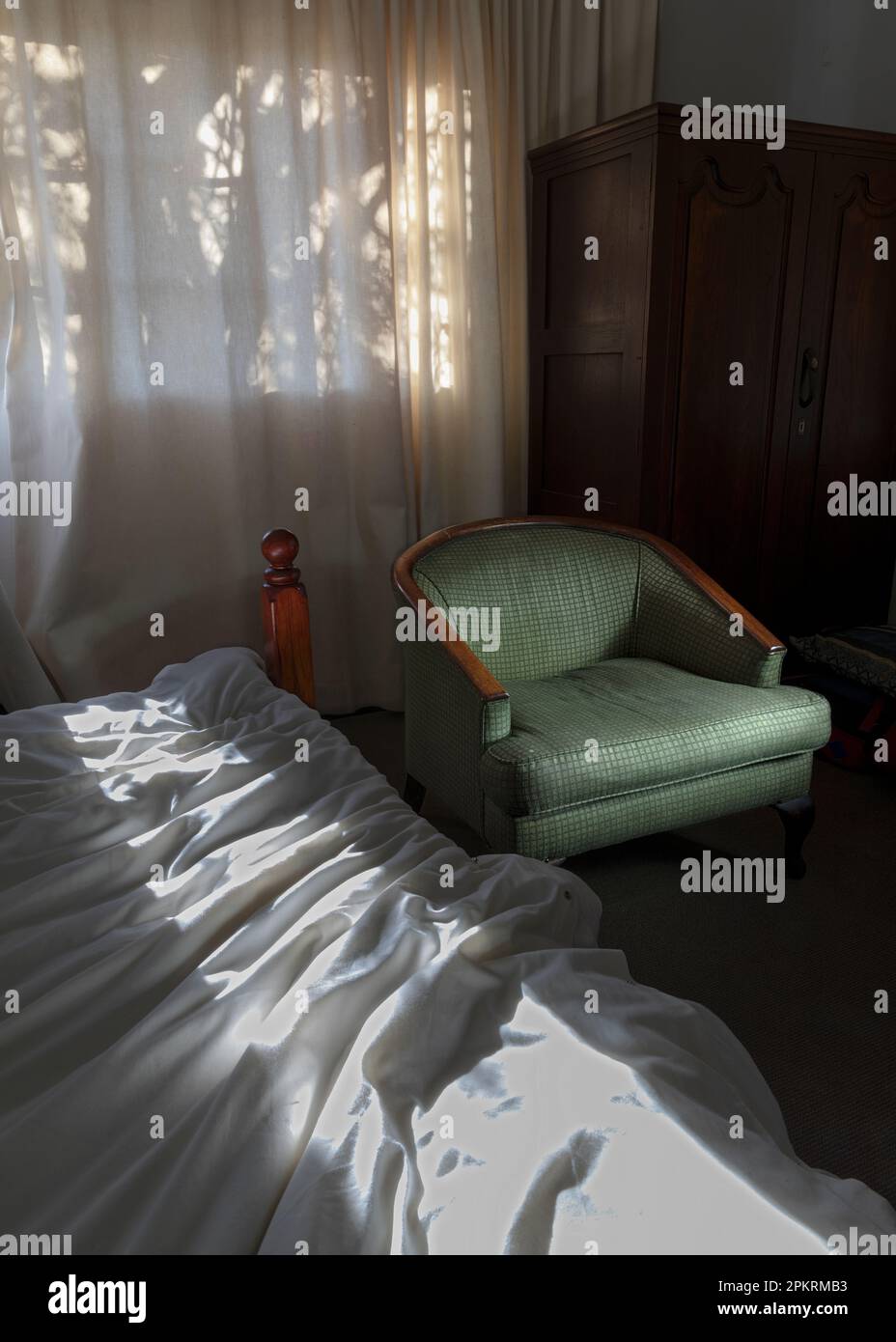 Chambre avec lit et chaise dans l'hôtel Himeville Arms. Banque D'Images