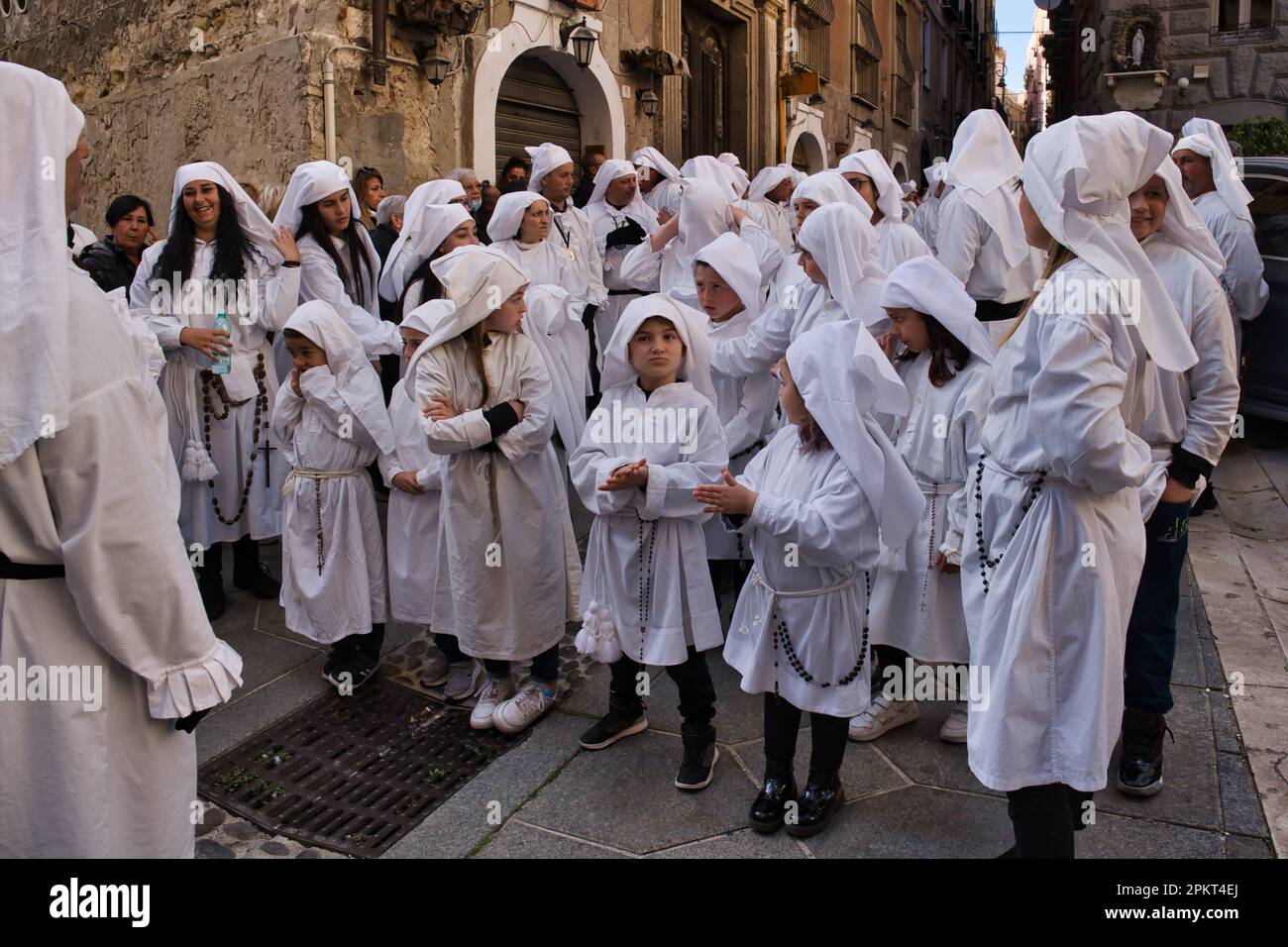 La chorale de fraternité chante des chansons religieuses pendant la procession de Pâques à travers les rues de la vieille ville de Cagliari Banque D'Images
