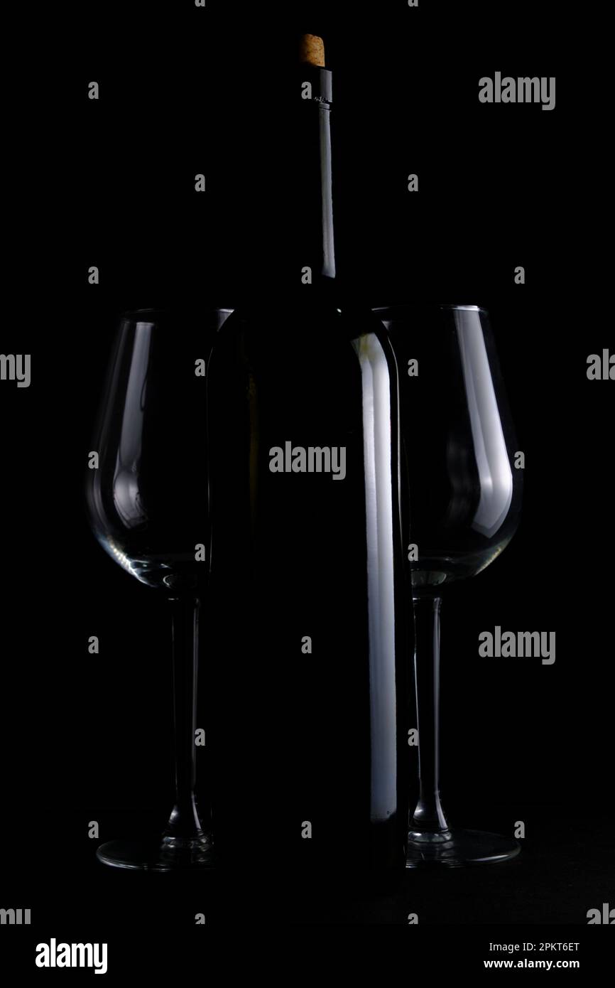 Bouteille de vin et deux verres à vin sur fond noir Banque D'Images