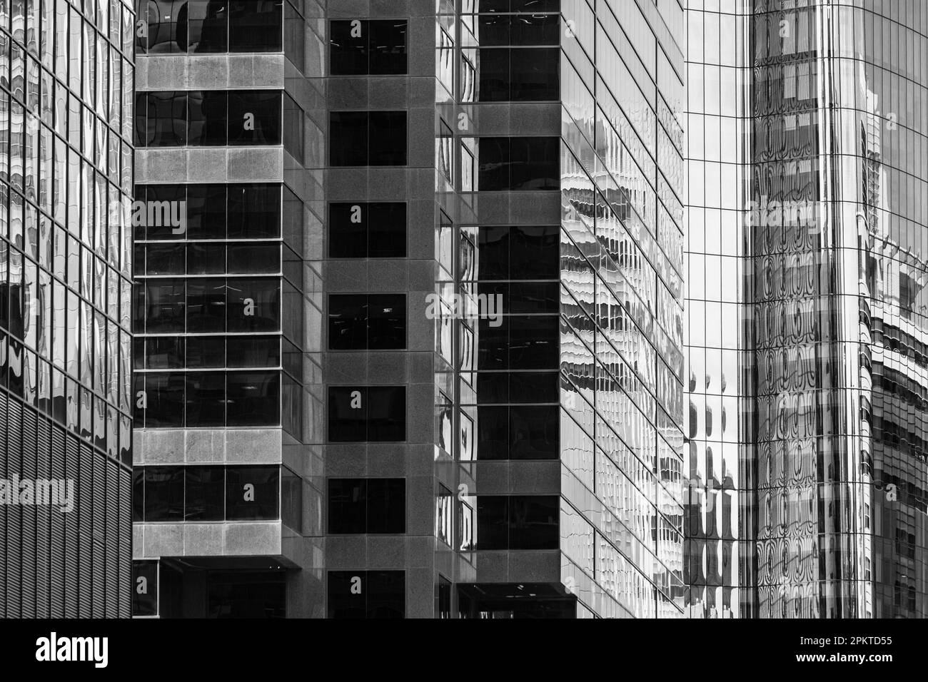 Fenêtres en verre et en acier urbain, détails architecturaux d'un bâtiment qui se chevauchent un autre Banque D'Images