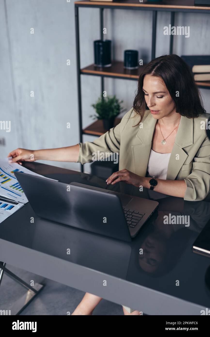 Femme au bureau de son bureau travaillant avec des documents. Banque D'Images