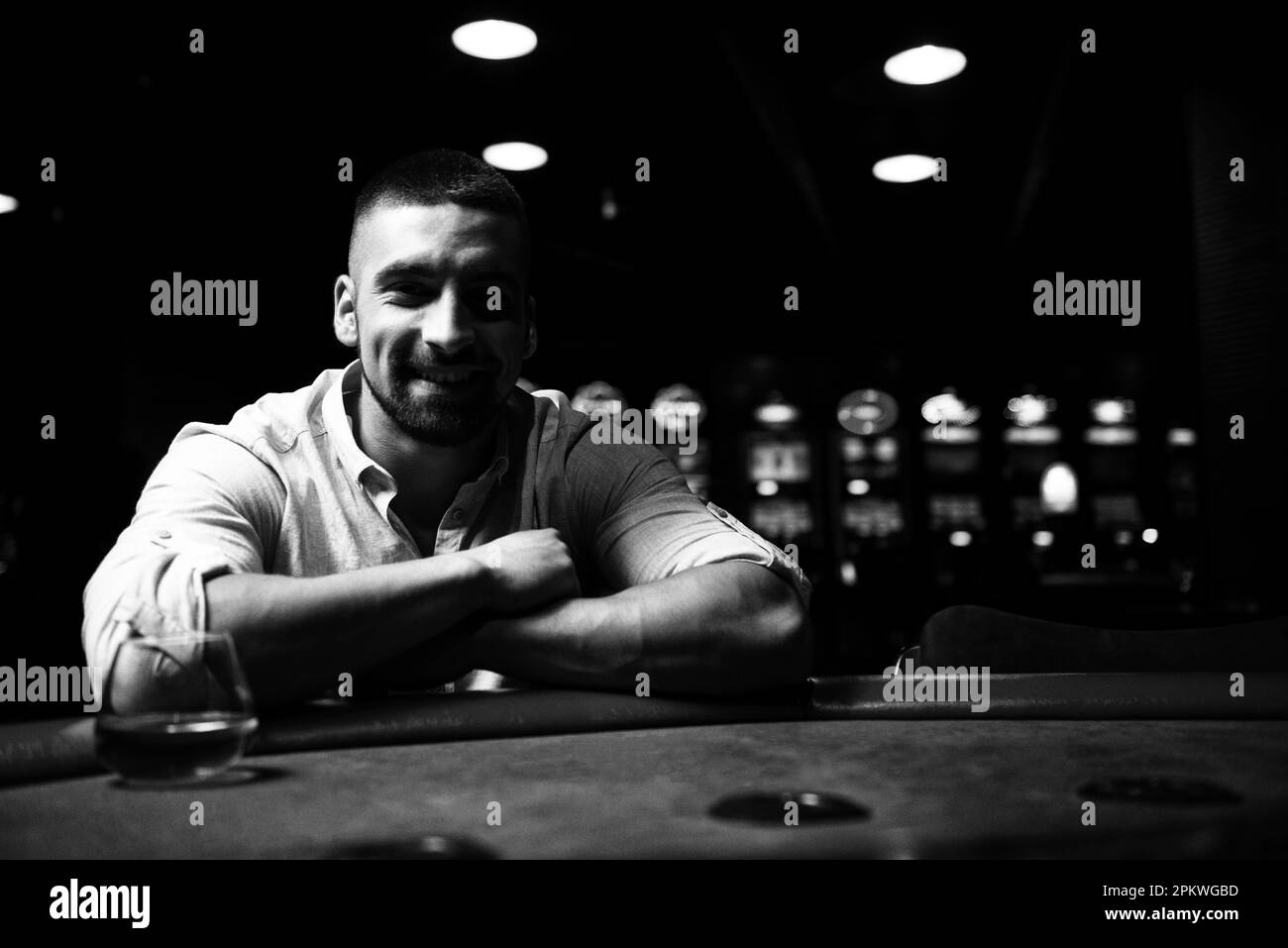 Jeune homme jouant au Blackjack derrière la table au Casino Banque D'Images