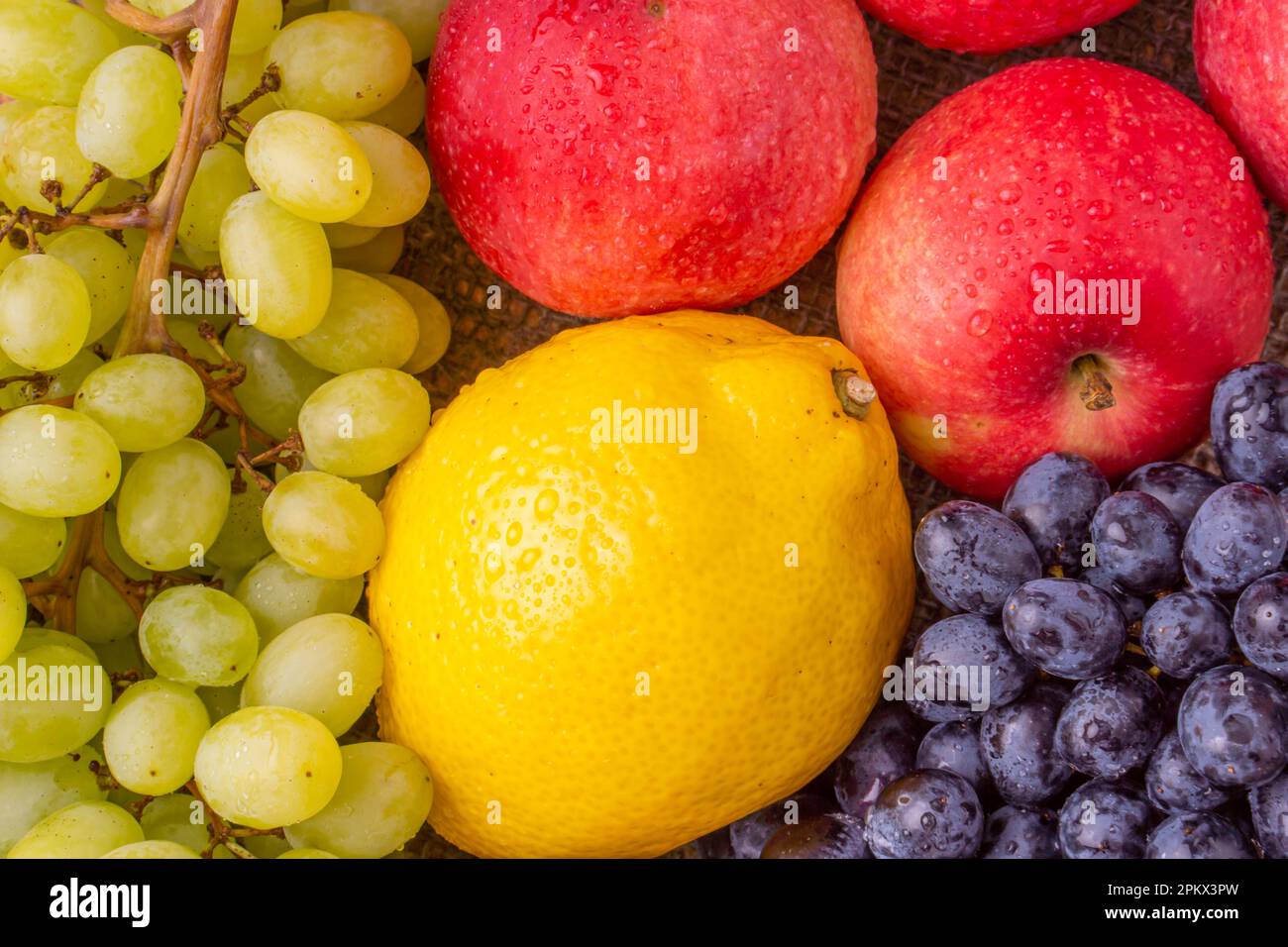 Raisins frais avec pommes rouges sur fond de bois Banque D'Images