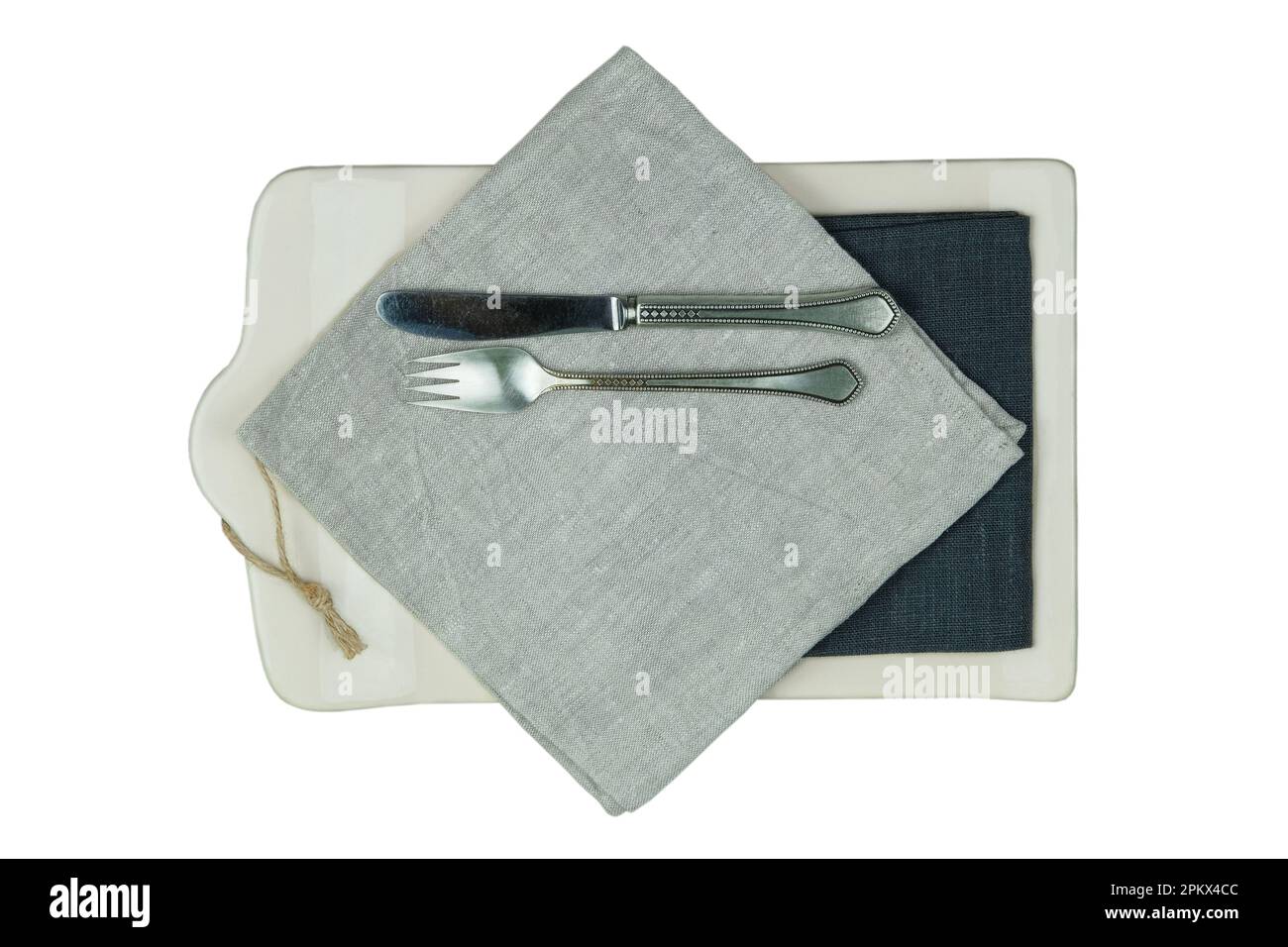 Fourchette avec un couteau et une table de cuisine avec une serviette en lin et un couteau avec une fourchette isolée sur fond blanc. Vue de dessus. Banque D'Images