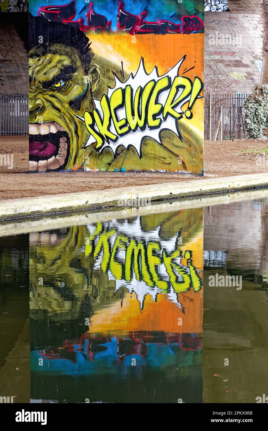 Réflexion sur la surface de l'eau d'une œuvre dramatique de graffiti peinte sur une colonne de béton New Haw England UK Banque D'Images