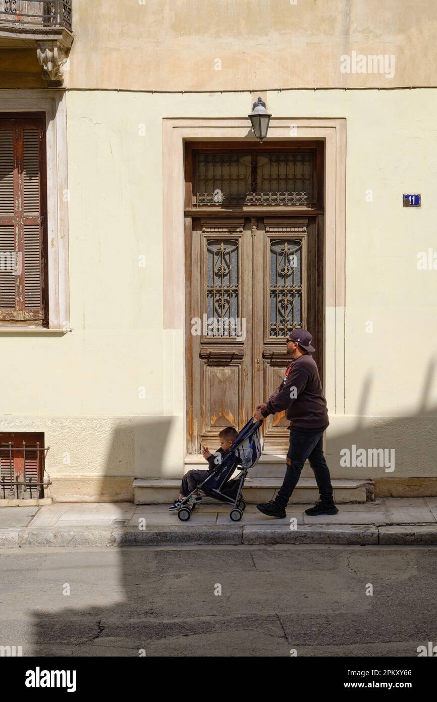 Papa poussant une poussette dans le quartier de Plaka à Athènes Banque D'Images