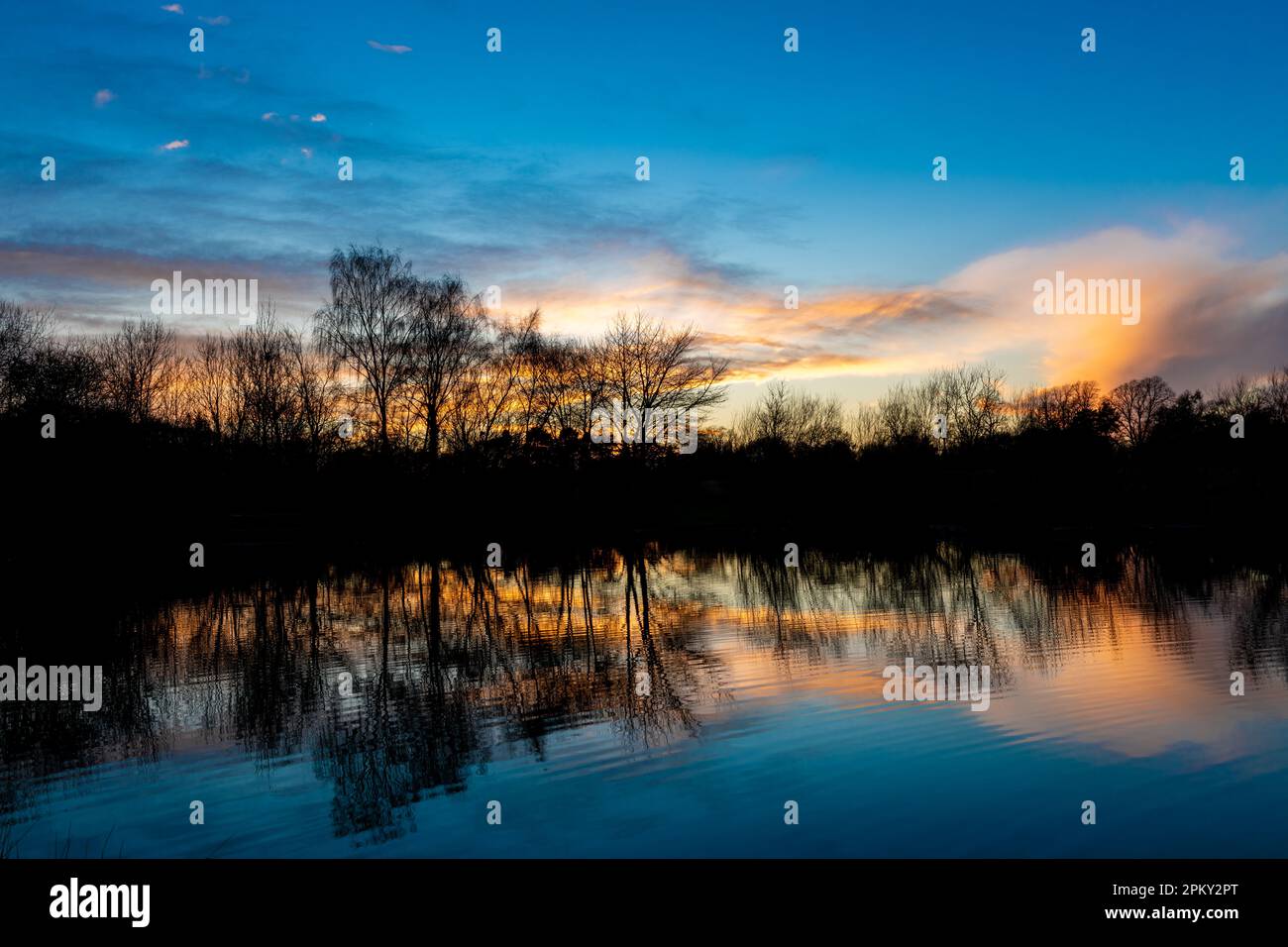 Coucher de soleil d'hiver sur un petit lac de pêche Bulwell Hall Park Nottingham uk Banque D'Images