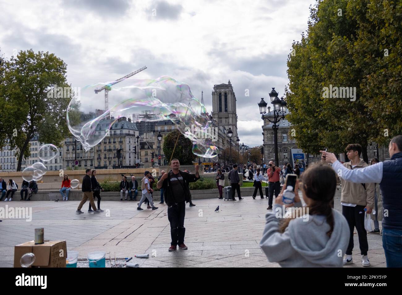 Smiling Bubble Man divertit les enfants avec Bubbly Magic en utilisant deux bâtons et une corde Banque D'Images