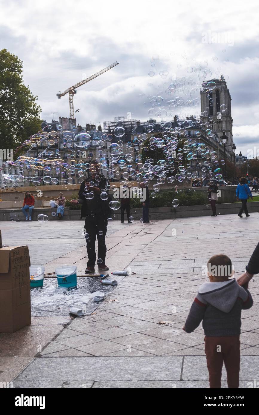 Homme soufflant de grosses bulles avec deux bâtons et une corde à Paris, France Banque D'Images