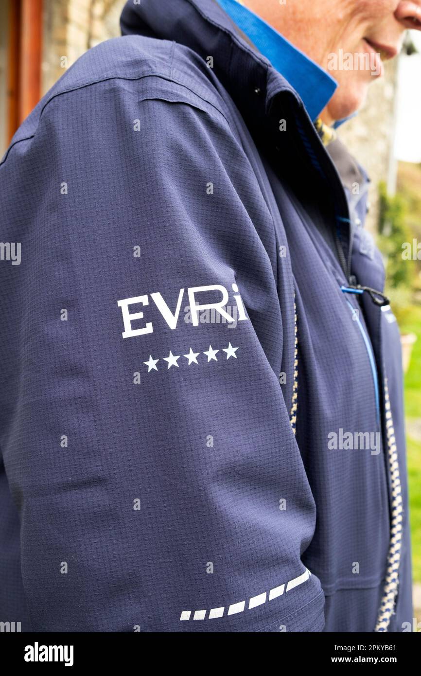 Logo du fournisseur de services EVRI lettres de signature sur un EVRI 5 étoiles employé livraison van ouvrier uniforme blouson Wales UK 2023 KATHY DEWITT Banque D'Images