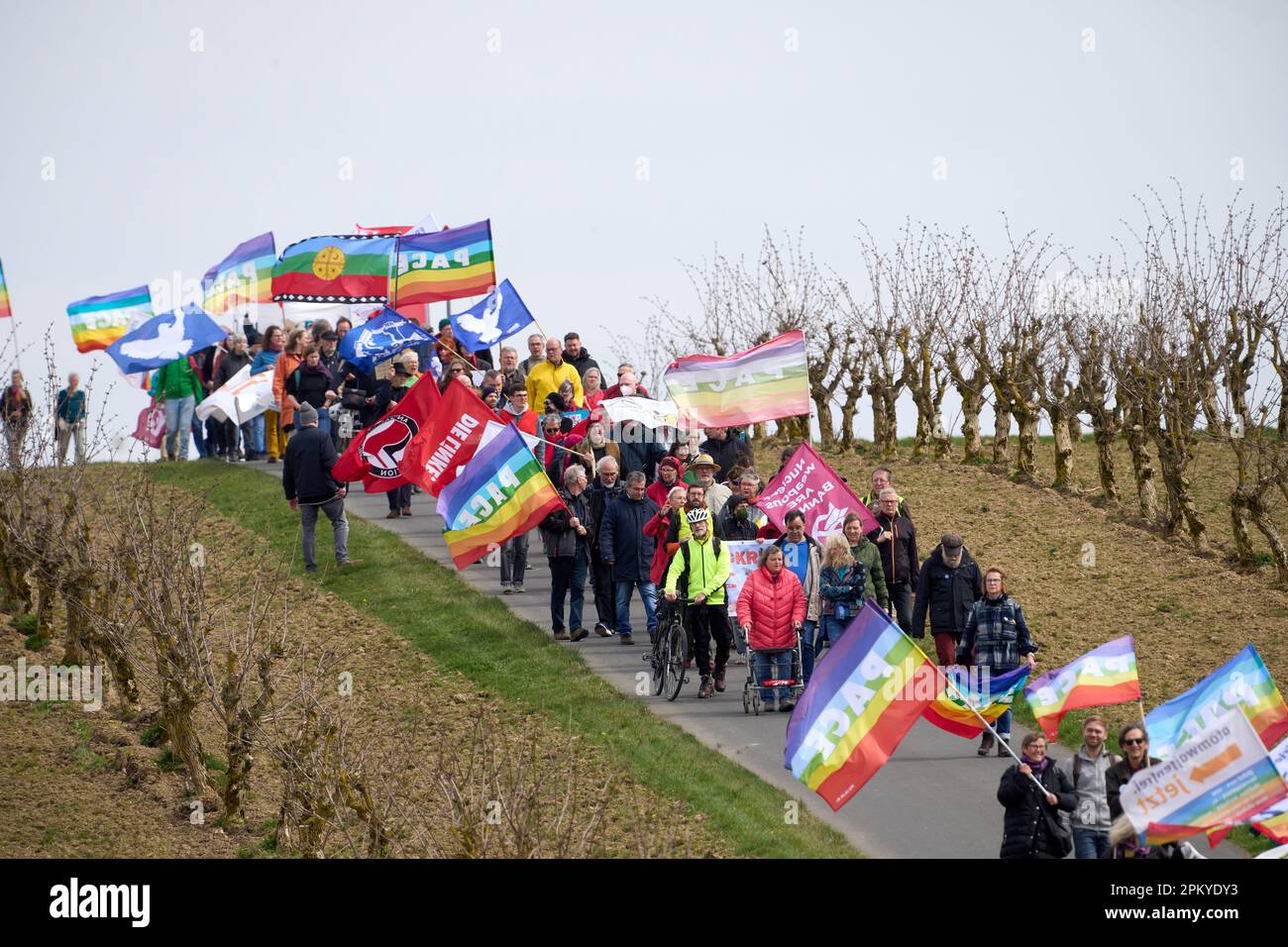 10 avril 2023, Rhénanie-Palatinat, Büchel : les participants à la marche de Pâques marchent à côté de la clôture de la base aérienne de la Bundeswehr. Toujours en 2023, sous l'impression de la guerre de la Russie contre l'Ukraine, de nombreuses marches de Pâques ont eu lieu dans toute l'Allemagne. Photo: Thomas Frey/dpa Banque D'Images