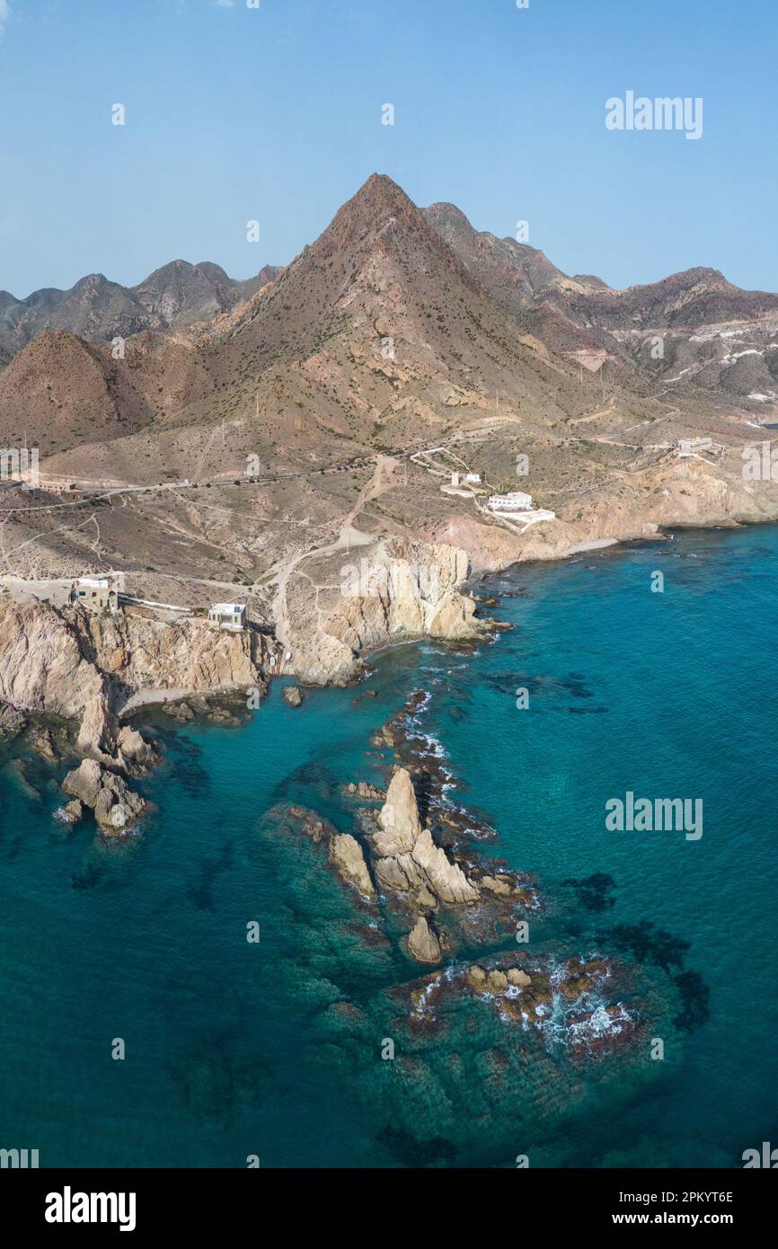 Vue de drone de formations rocheuses rugueuses situées près de la mer ondulée contre le ciel bleu à Almeria Banque D'Images