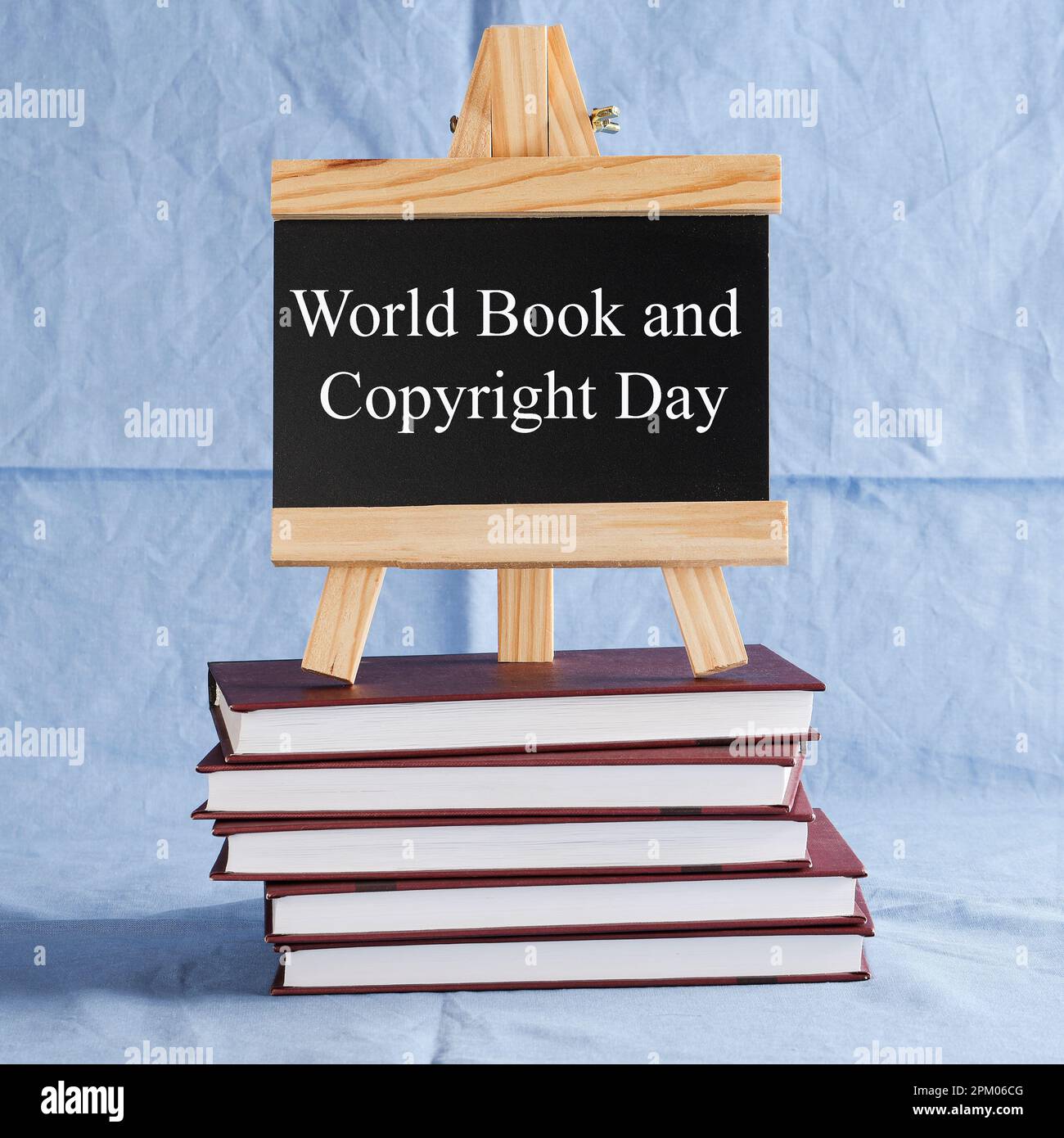 World Book and Copyright Day écrit sur tableau noir sur pile de livres sur fond bleu. réserver des vacances, concept d'éducation Banque D'Images