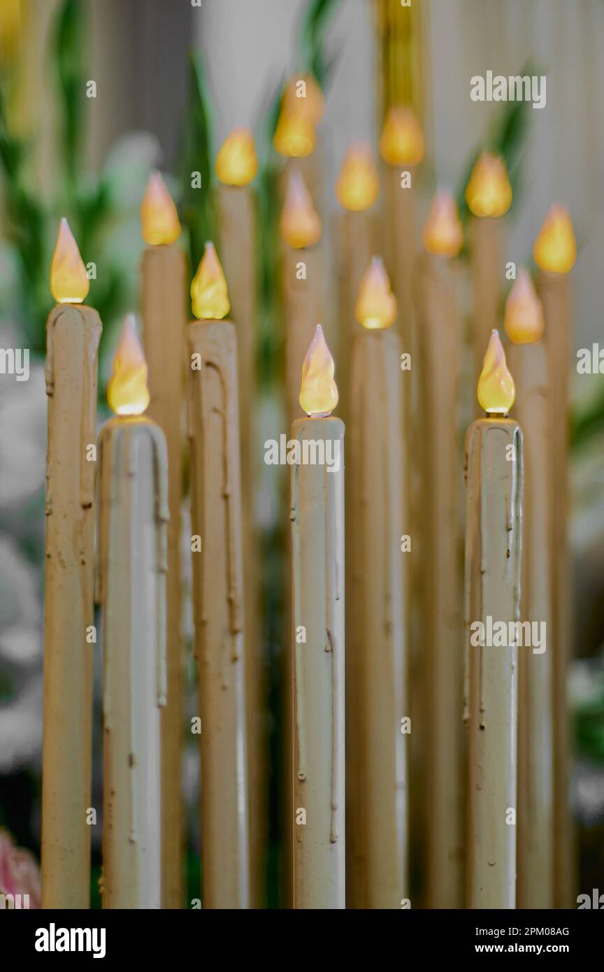 Photo verticale d'un groupe de bougies artificielles en plastique avec des ampoules simulant des flammes, la première étant dans un foyer sélectif Banque D'Images