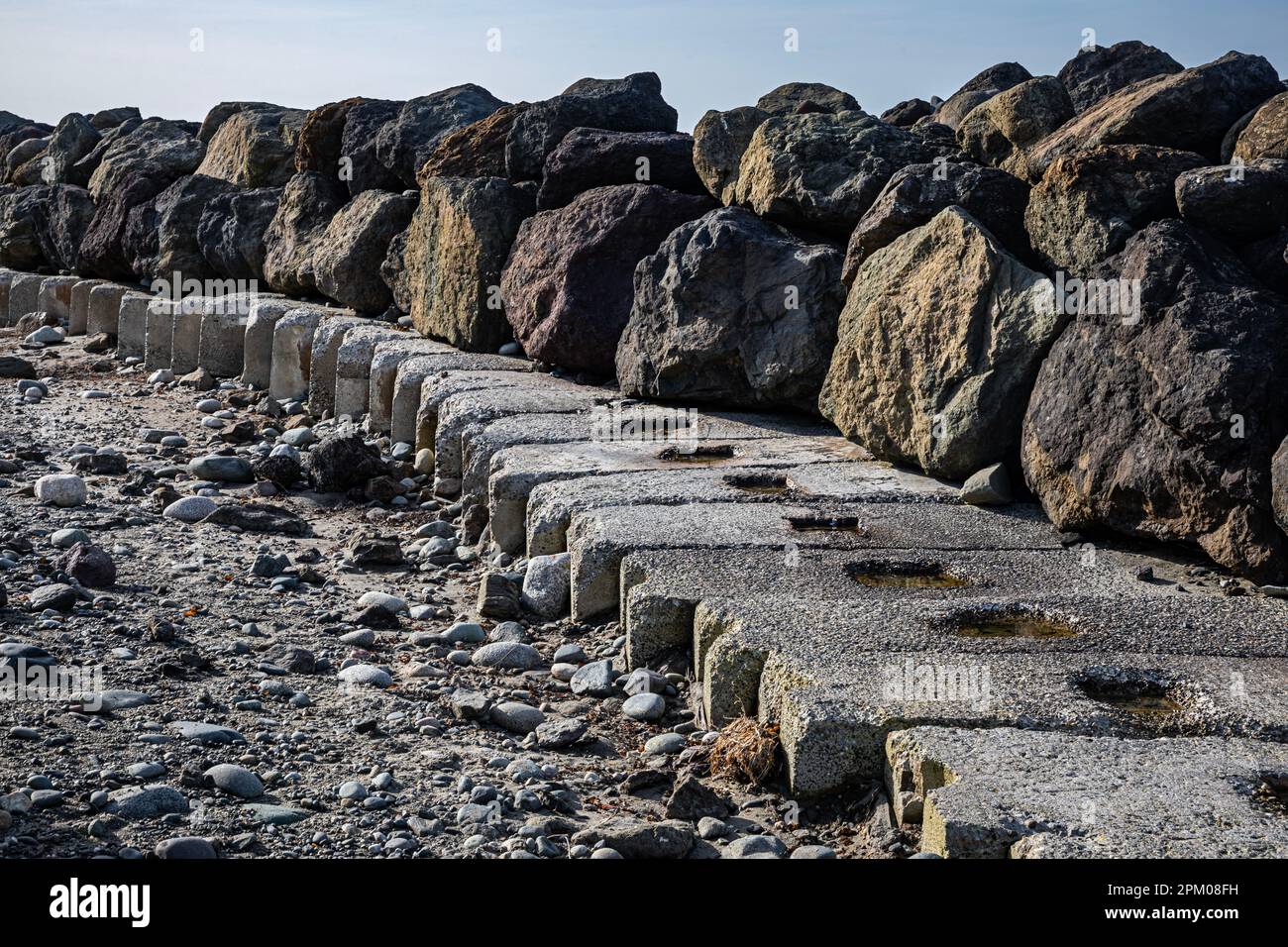 WA23276-00...WASHINGTON - Boudders et blocs de ciment protégeant les terrains et les bâtiments du phare de point Wilson contre l'érosion. Banque D'Images