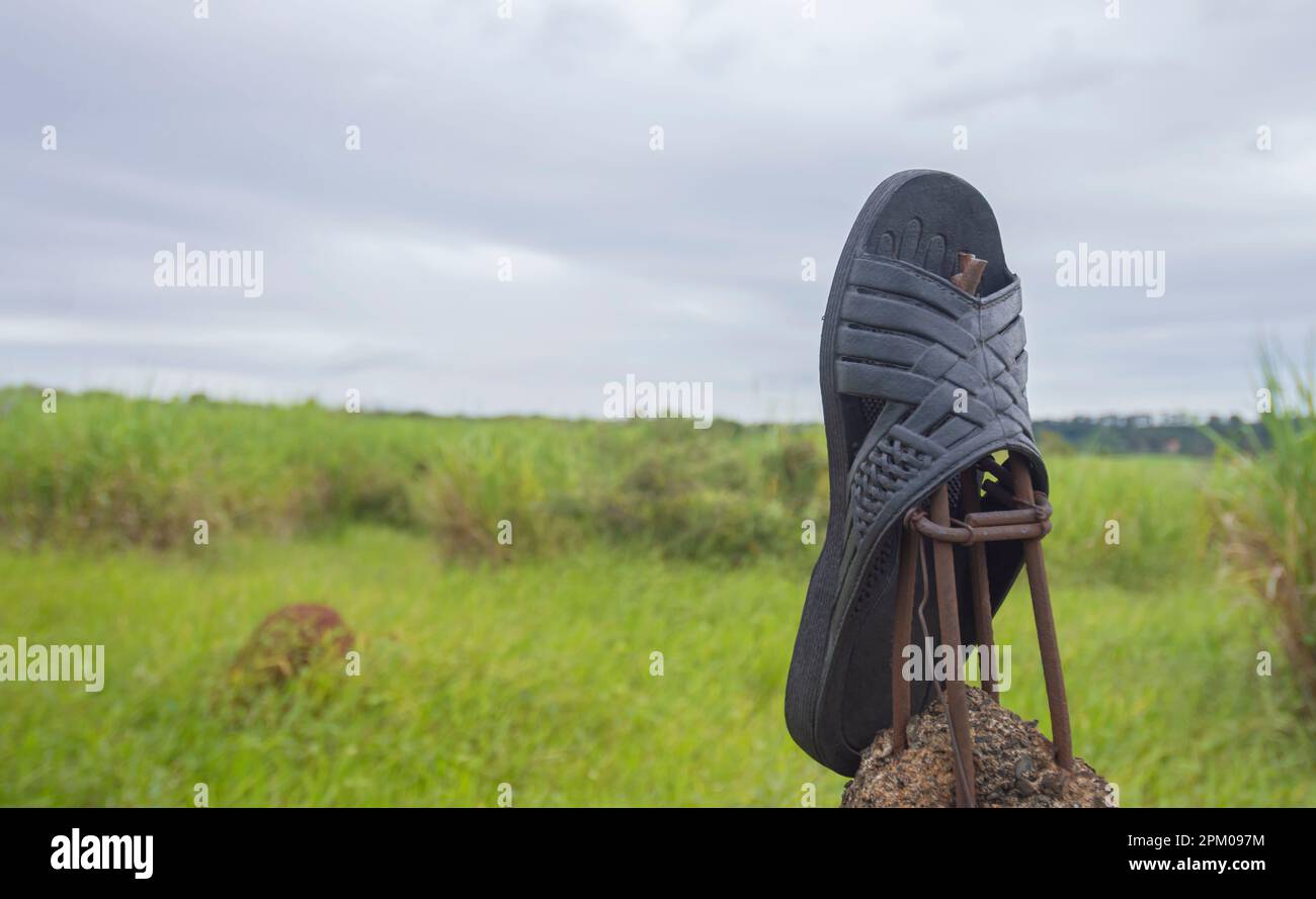 Glisseur laissé sur une clôture avec la végétation en arrière-plan sur un jour nuageux, concept de pollution de la nature. Banque D'Images