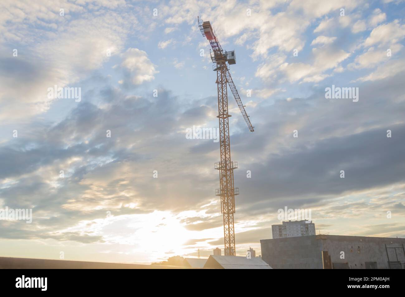 grue géante dans une construction en cours avec la ville en arrière-plan en fin d'après-midi. Banque D'Images
