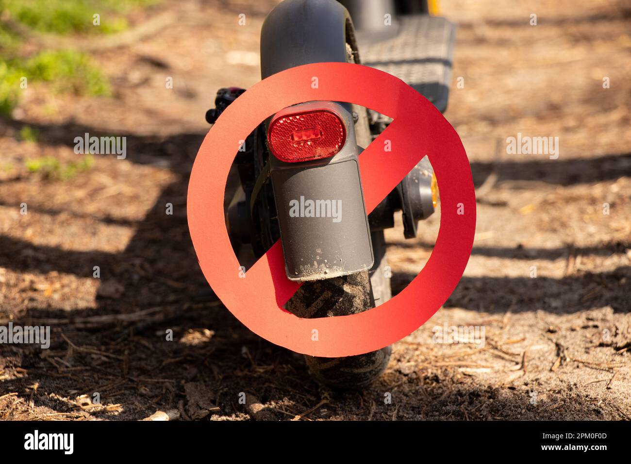 Scooter électrique et panneau d'interdiction sur la roue sur le scooter sur les routes dans les parcs au soleil, le transport urbain et l'interdiction Banque D'Images