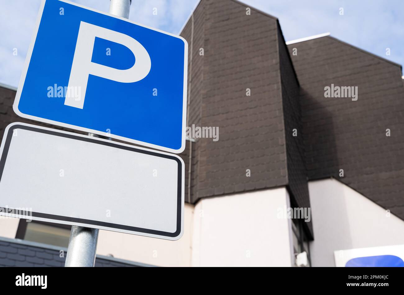 Panneau de parking avec espace pour le texte et un bâtiment en arrière-plan Banque D'Images Panneau de parking avec espace pour le texte et un bâtiment en arrière-plan Banque D'Images