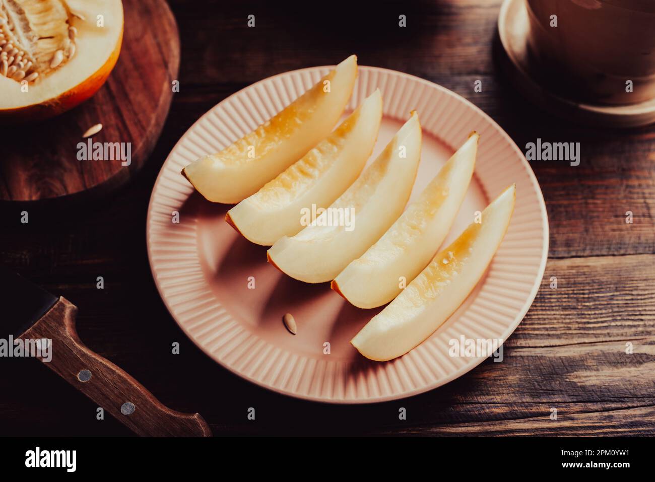 Plaque de Melon mûr en tranches de miellat sur table en bois Banque D'Images