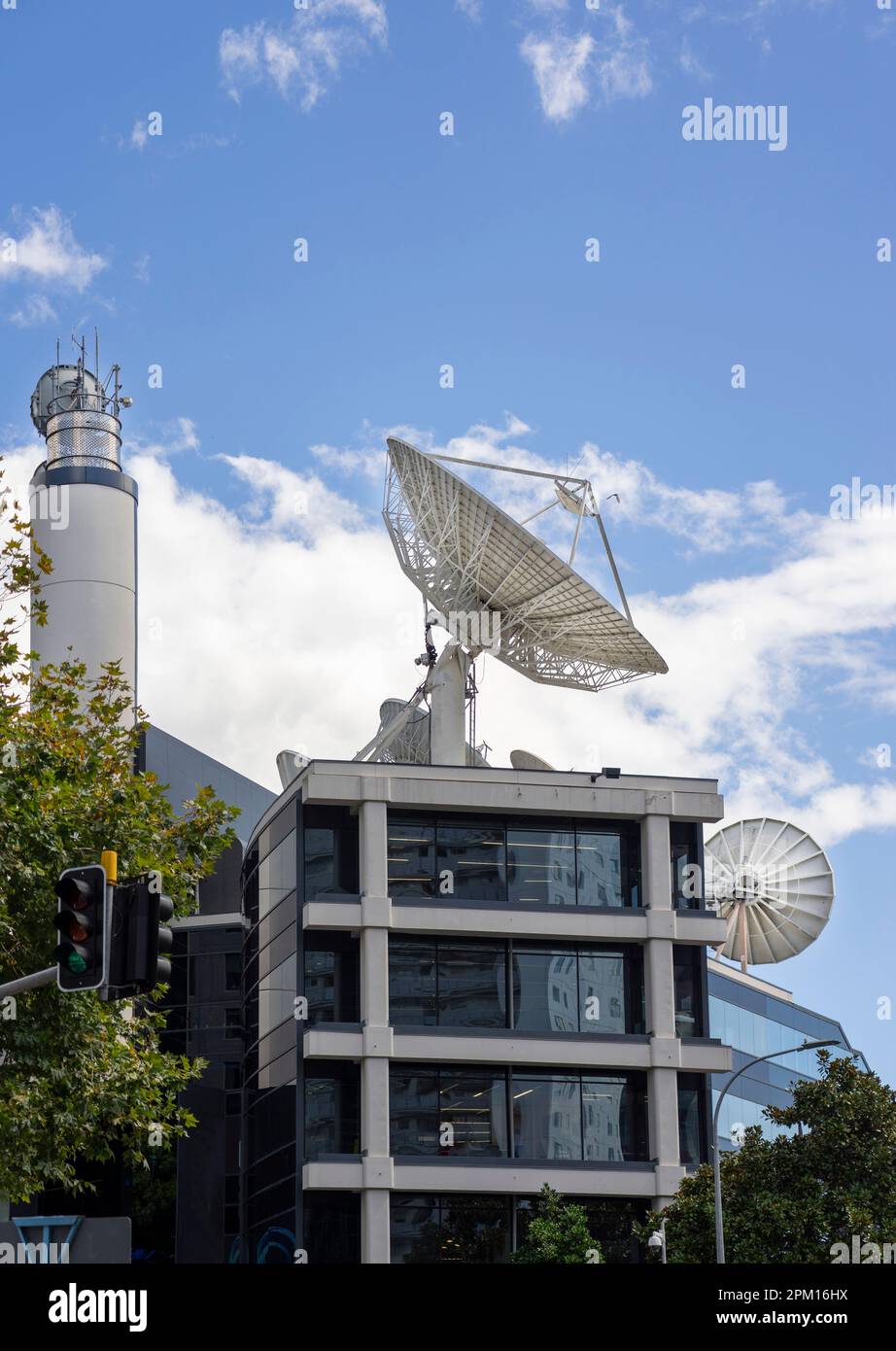 Immense disque d'antenne de télévision sur le toit du bâtiment sur fond de ciel bleu et de nombreux nuages Banque D'Images
