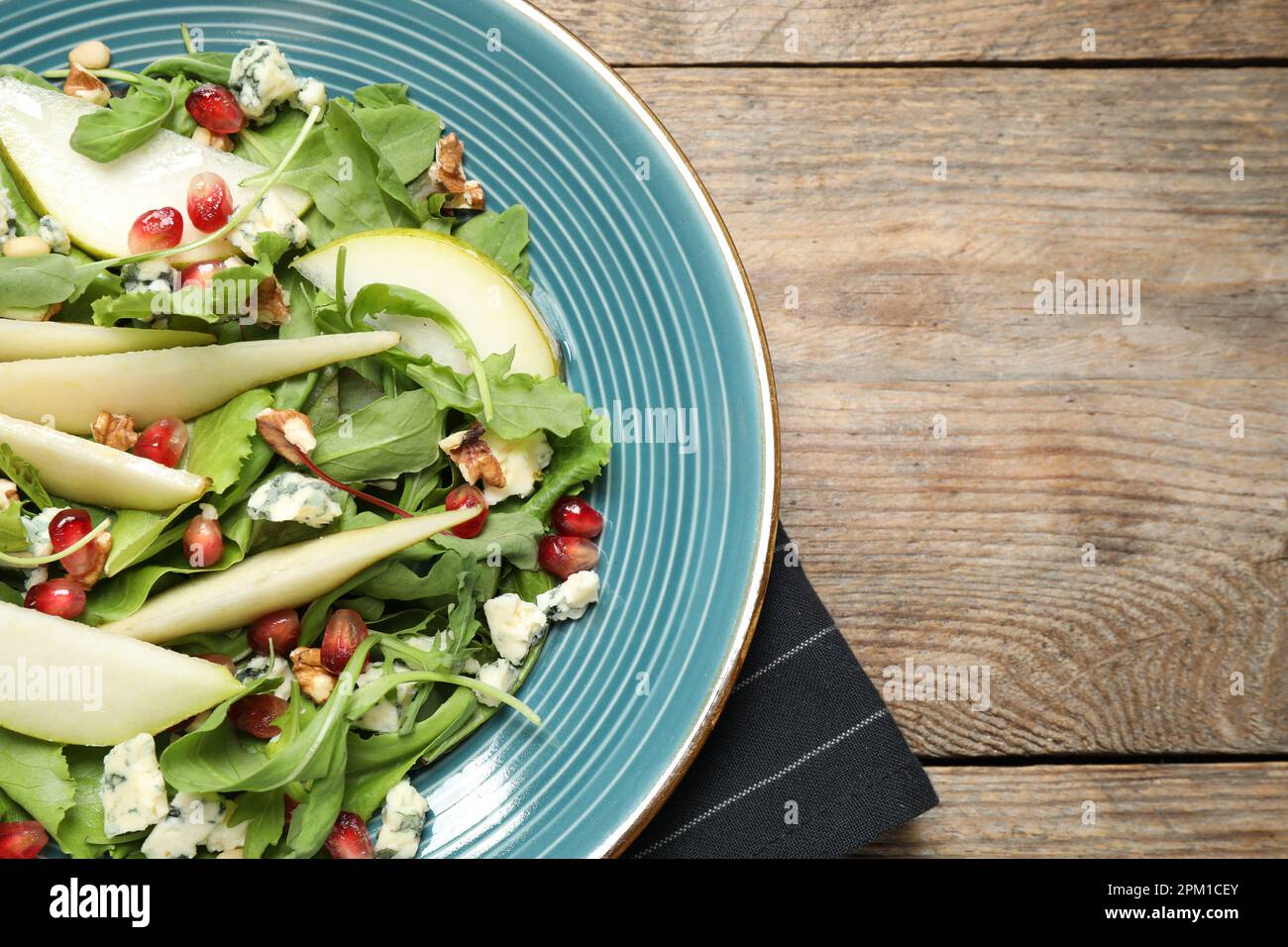Salade fraîche avec poire sur table en bois, vue sur le dessus. Espace pour le texte Banque D'Images