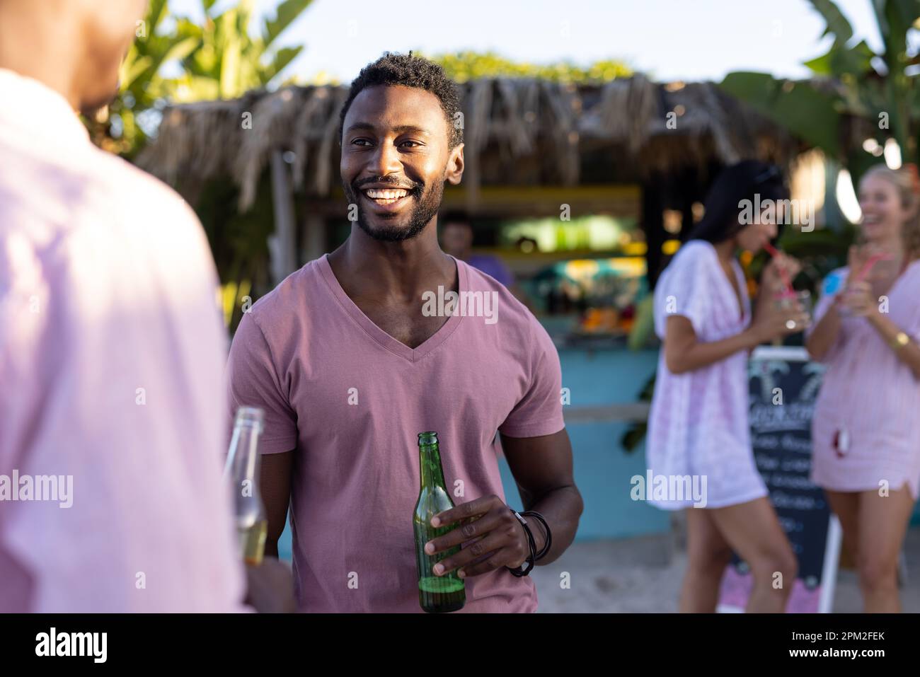 Heureux divers amis ayant la fête à la plage, de boire des cocktails et de la bière Banque D'Images