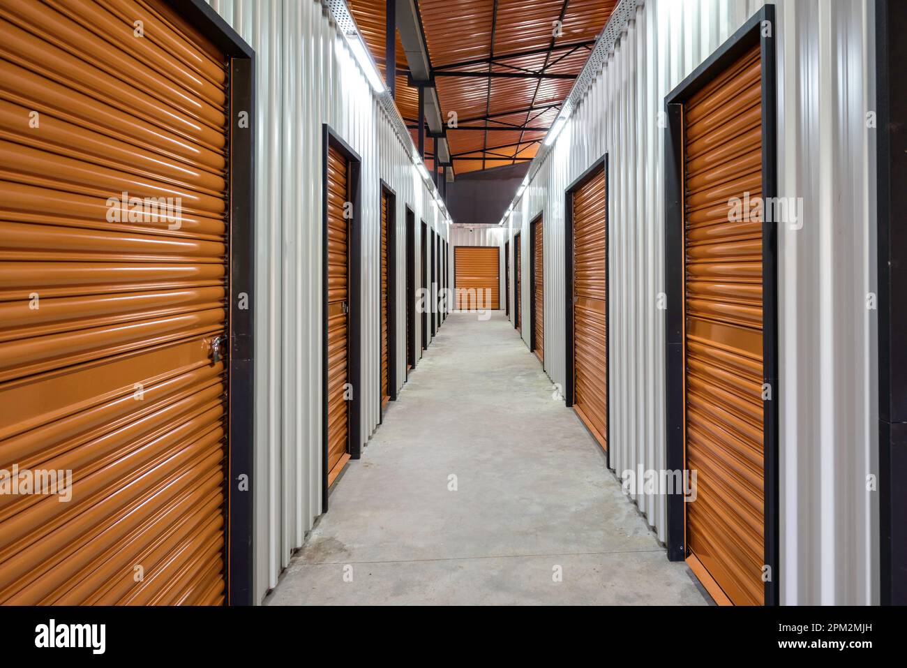 Couloir de l'unité de rangement avec portes rouges. Unités de stockage de location Banque D'Images
