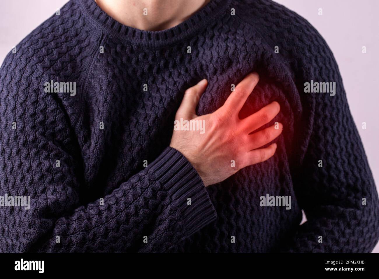 Homme ayant une crise cardiaque. Homme tenant sa poitrine en douleur aiguë. Symptôme de crise cardiaque - Santé et concept médical. Zone douloureuse mise en évidence en rouge Banque D'Images