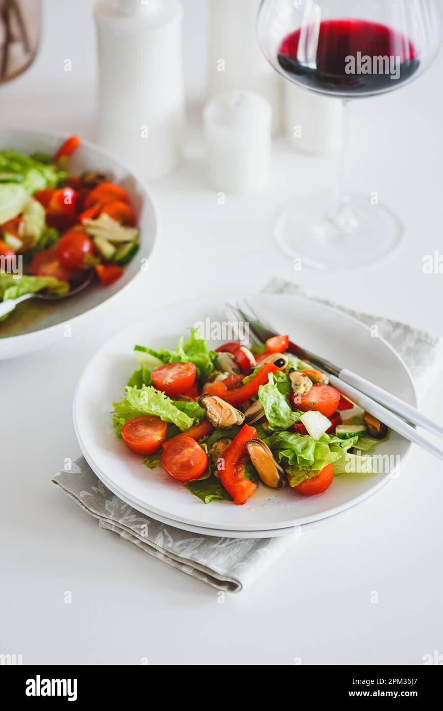 Salade fraîche avec moules et tomates sur table en bois blanc Banque D'Images