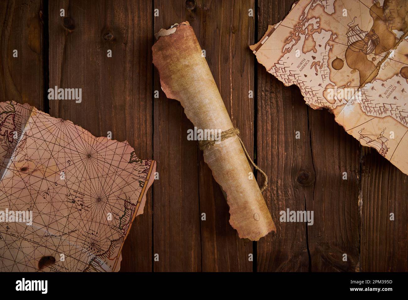 Un parchemin antique avec de vieilles cartes sur une table en bois. Banque D'Images