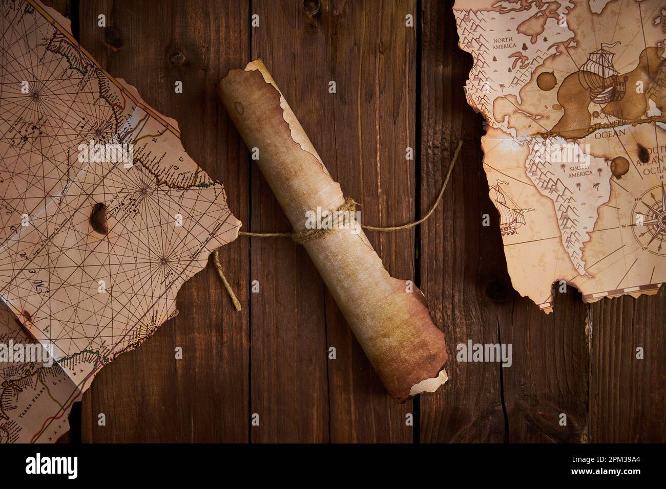 Un parchemin antique avec de vieilles cartes sur une table en bois. Banque D'Images