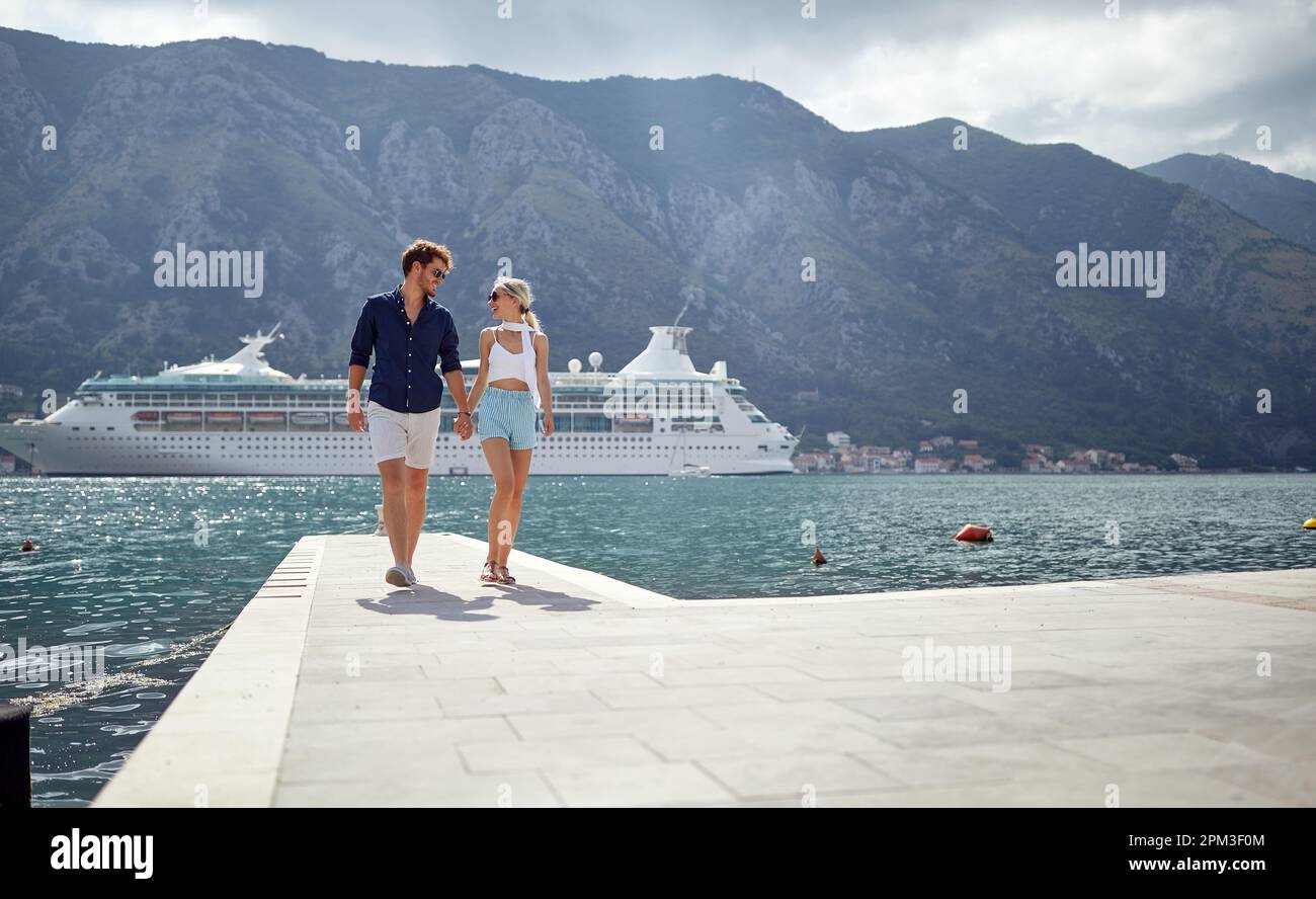 Un jeune couple qui profite d'une promenade sur le quai lors d'une belle journée tout en passant des vacances en bord de mer. Amour, relation, vacances, mer Banque D'Images