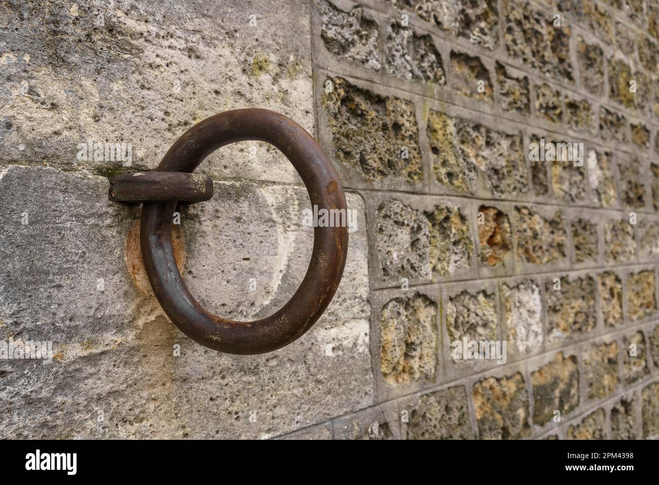 Gros plan d'un anneau d'amarrage en fer sur un mur de pierre le long de la Seine à Paris, France. Banque D'Images