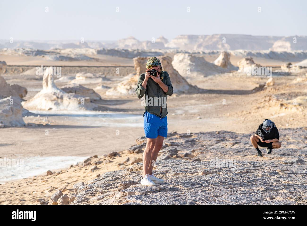 Deux touristes explorant et prenant des photos dans le paysage rocheux du désert blanc à Bahariya en Egypte Banque D'Images