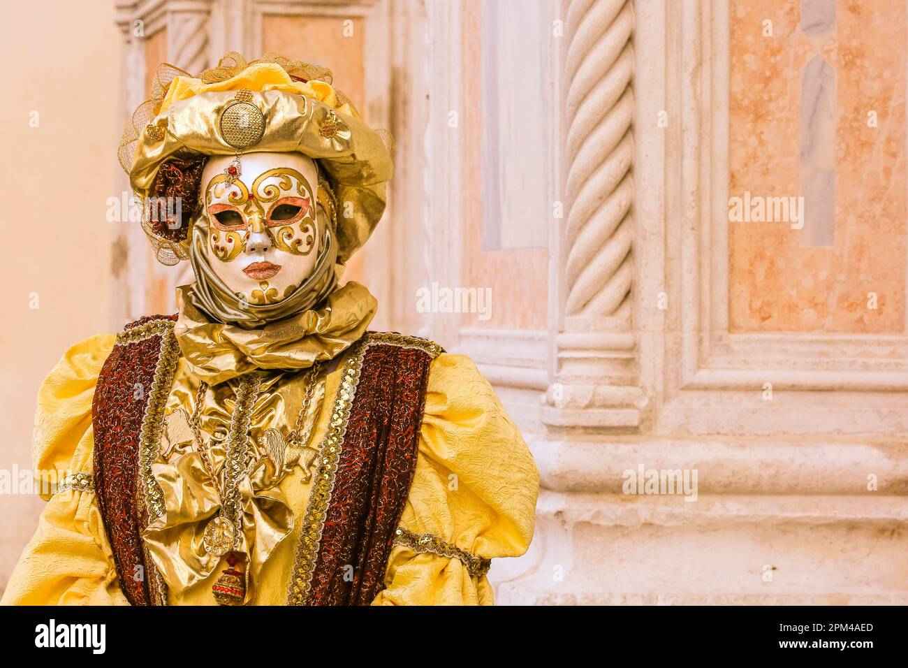 Carnaval de Venise, participant costumé en chapeau d'or, masque et robe vénitienne historique, Venise, Italie Banque D'Images