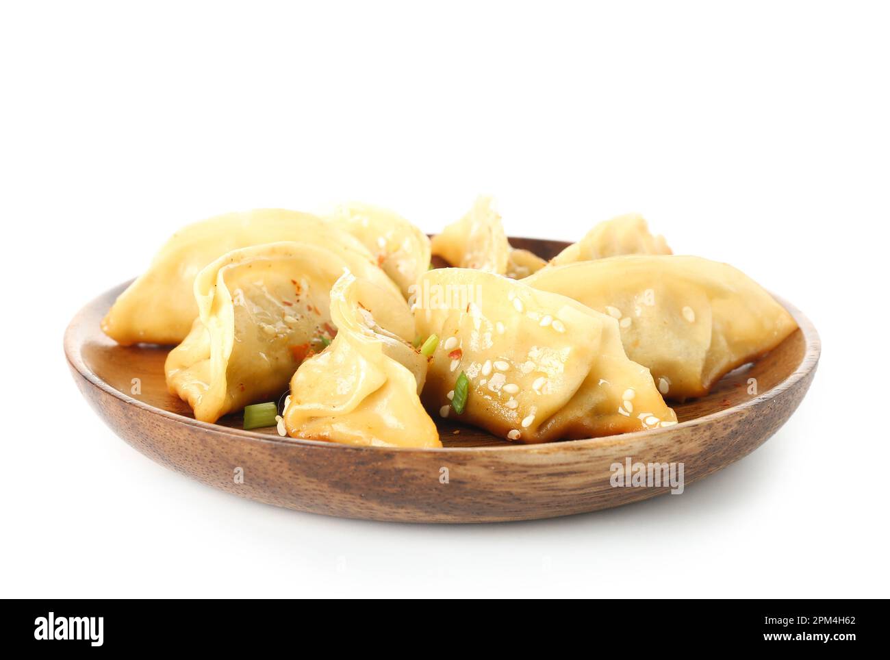 Assiette avec de savoureux jiaozi chinois, oignon vert et sésame sur fond blanc Banque D'Images