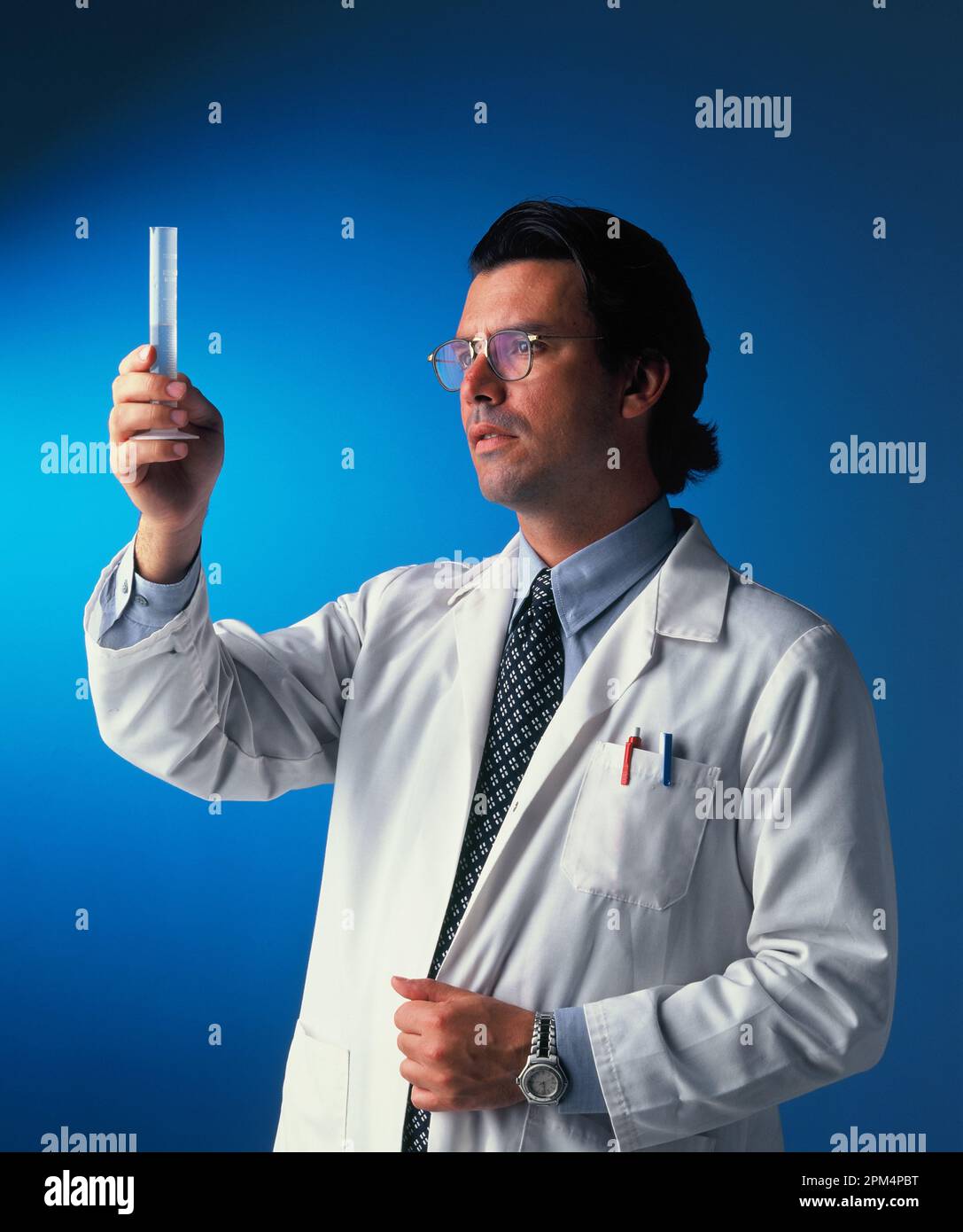 Un professionnel de la santé regarde l'échantillon dans un flacon en verre. Banque D'Images