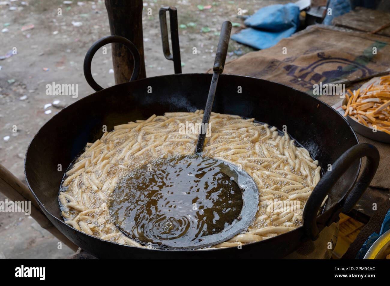 Howrah, Bengale-Occidental, Inde - 26.10.2020 : Nimki, une nourriture épicée indienne très populaire est en cours de préparation dans une cabine de nourriture du côté de la route. Banque D'Images