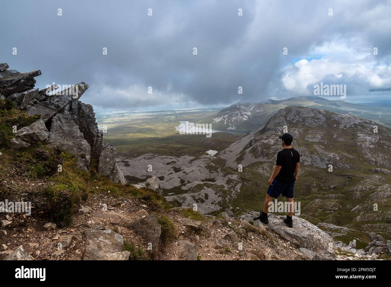 Homme debout au sommet de la montagne et admirant le paysage de la montagne Errigal Banque D'Images