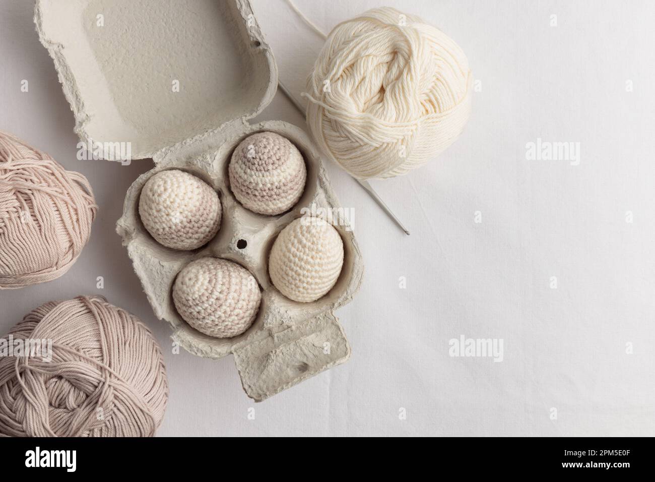 Ensemble d'œufs crochetés de pâques mignons, couleur pastel dans la boîte à œufs Banque D'Images