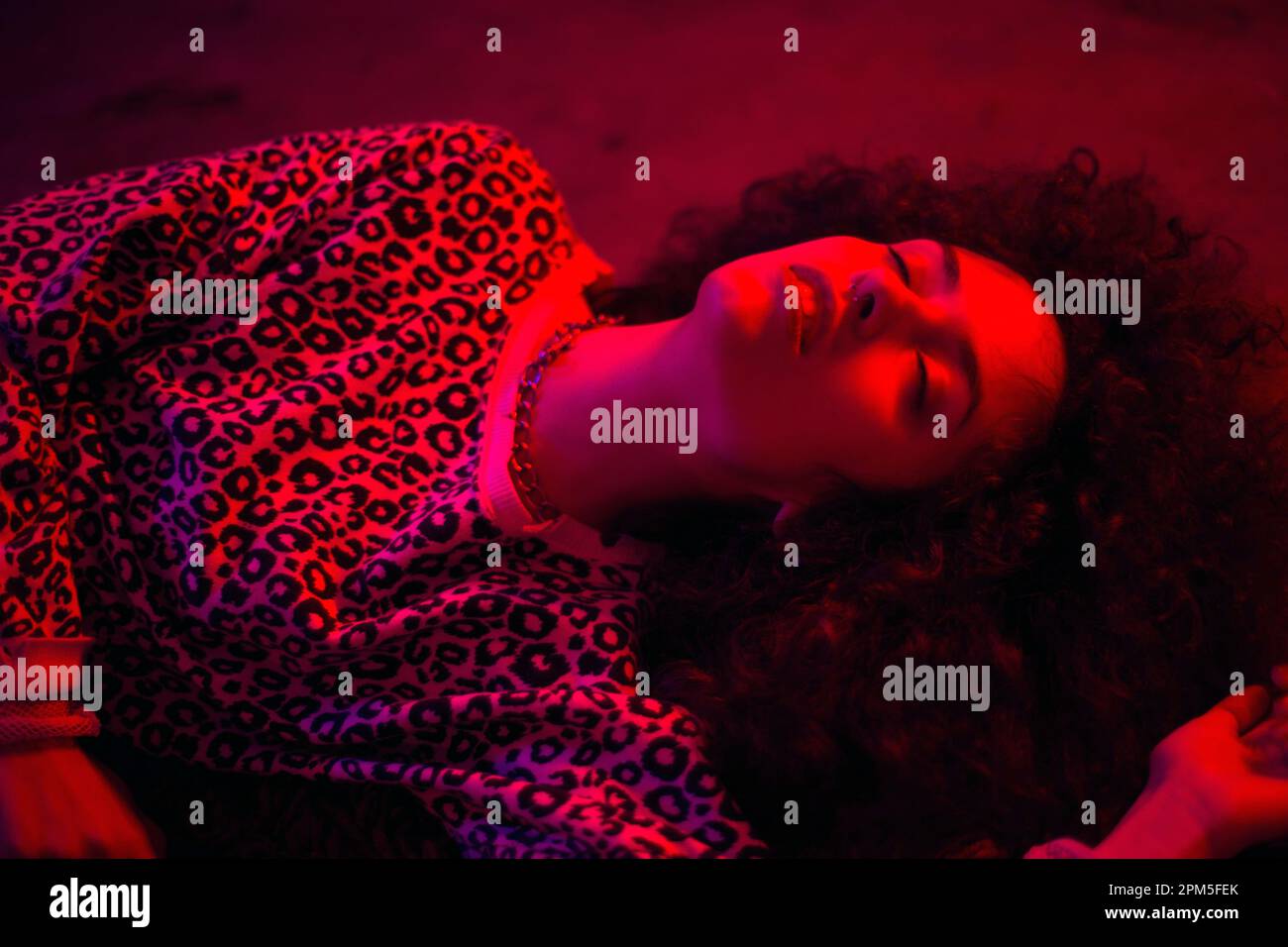 Gros plan Portrait d'une jeune femme mauriquement sous lumière rouge Banque D'Images