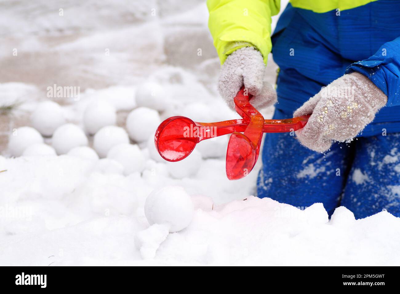 Une fille en costume brillant fait des boules de neige Banque D'Images