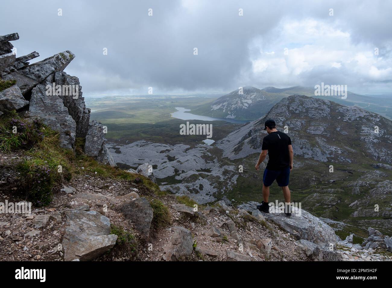 Homme debout au sommet de la montagne et admirant le paysage de la montagne Errigal Banque D'Images