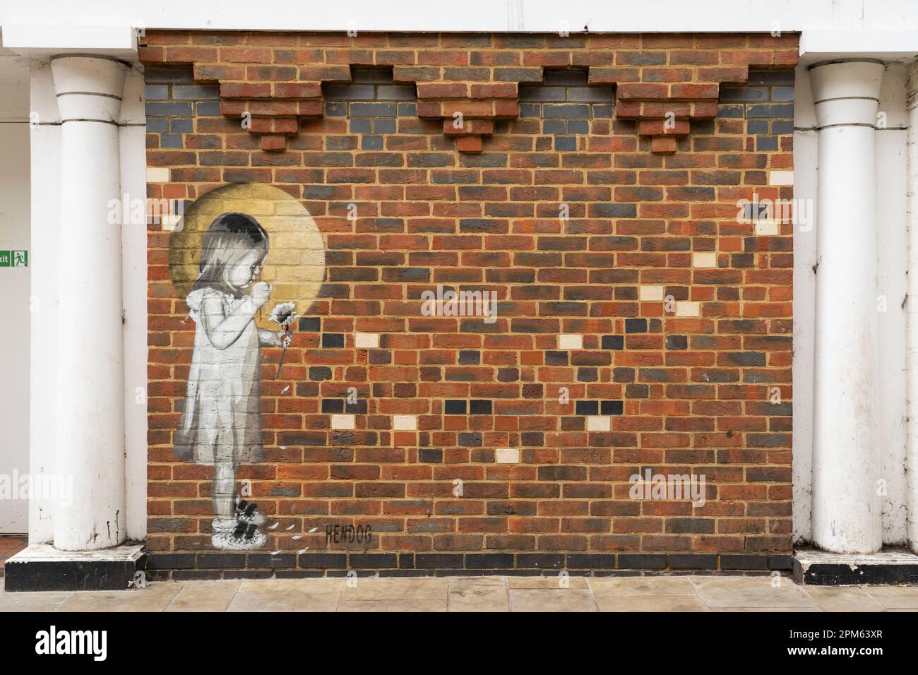 Pochoir graffiti murale d'une fille tenant une fleur de Marguerite et enlever les pétales sur Market Street par l'artiste de rue Hendog. Winchester, Royaume-Uni Banque D'Images