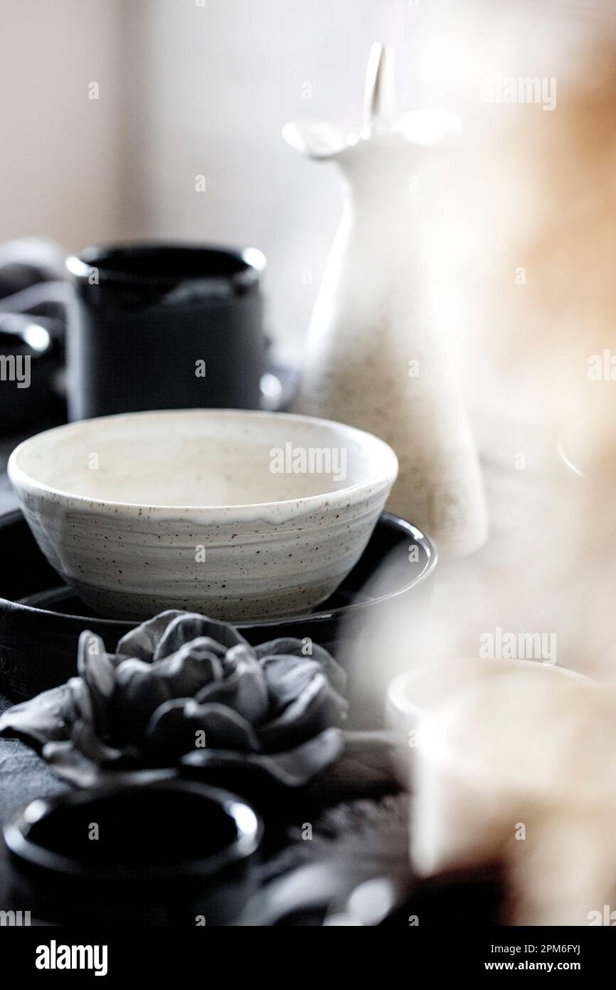 Table rustique avec vaisselle en céramique artisanale vide, bols rugueux  noir et blanc, tasses, verseuse et vase sur nappe en lin. Fleur en roseau  sèche Photo Stock - Alamy